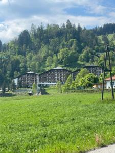 a large field of grass with buildings in the background at vom See auf die Skipiste in Feldkirchen in Kärnten