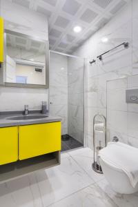 y baño con lavabo amarillo y ducha. en Bayram Apart Hotel, en Alanya