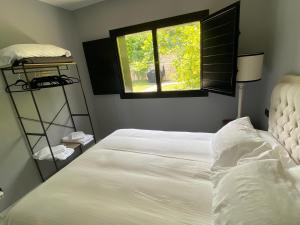 sypialnia z białym łóżkiem i oknem w obiekcie Mundaka Beachfront House w mieście Mundaka