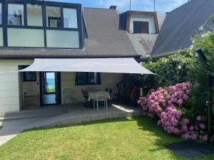 une maison avec un parasol blanc dans la cour dans l'établissement Mundaka Beachfront House, à Mundaka