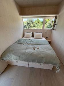 a bed in a small room with a window at BUQEZ ECO RESORT - Beach Villas 2 and 8 - Seaview, new wifi! in Drage