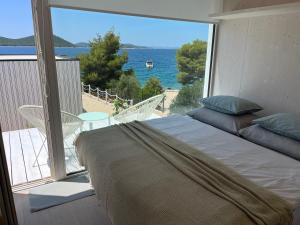 a bedroom with a bed and a view of the ocean at BUQEZ ECO RESORT - Beach Villas 2 and 8 - Seaview, new wifi! in Drage