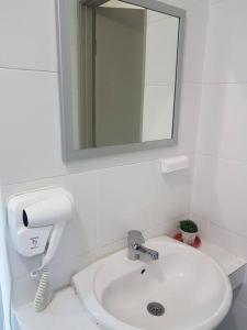 a white bathroom with a sink and a mirror at WingsNest Cameron Town Night Market High Speed Wi-Fi in Tanah Rata +34 photos