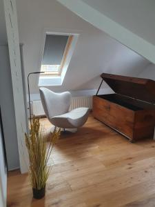 einen weißen Stuhl und einen Schreibtisch in einem Zimmer in der Unterkunft FEWO am Dele Park in Wilhelmshaven