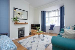 a living room with a blue couch and a table at Budleigh Burrow in Budleigh Salterton