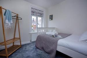 1 dormitorio con cama y escalera junto a una ventana en Budleigh Burrow en Budleigh Salterton