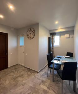 a dining room with a table and a clock on the wall at FRESH Apartments in Ossiach