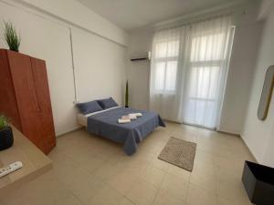 a small room with a bed and a window at Godson Apartment in Haifa