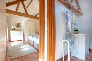 1 dormitorio con 1 cama en una habitación con vigas de madera en Whitley Farm Dairy, en Northleigh