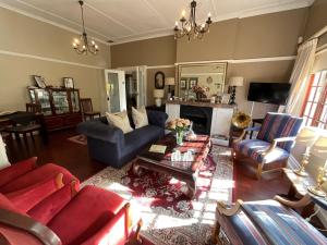 Elle comprend un salon doté d'un mobilier rouge et d'une cheminée. dans l'établissement Brighton Lodge - #Solar Energy #No Loadshedding, à Port Elizabeth