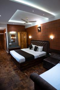 マジナグディにあるThe Nest Inn Resortのベッド2台とソファが備わるホテルルームです。