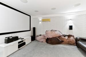 een woonkamer met een bank en een flatscreen-tv bij 5 bedroom Villa Poseidon with private pool, Aphrodite Hills Resort in Kouklia