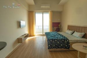 a hotel room with a bed and a large window at Taj Suites & Studios-Top Place Couple Friendly Stay at Luxury Gaur City Mall #Movie, #Food Court #Shopping in Ghaziabad