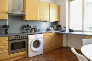 eine Küche mit Waschmaschine und Trockner in der Unterkunft Modern Apartment, 3 min to "U3 Neubaugasse" in Wien