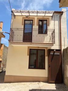 una grande casa con balcone e porta di casa vacanza caffe' a Roccavaldina