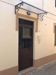 una porta sul lato di un edificio di casa vacanza caffe' a Roccavaldina