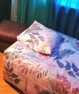 ビャウィストクにあるRetro CHARME CENTRUMの花のシーツと枕付きのベッド