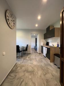 a kitchen and living room with a clock on the wall at FRESH Apartments in Ossiach