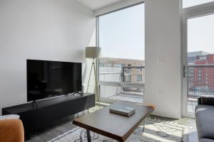 a living room with a large television and a coffee table at East Cambridge 2br w gym wd nr green line BOS-876 in Boston
