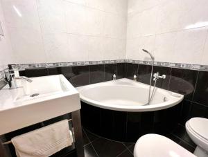 ein Badezimmer mit Badewanne, Toilette und Waschbecken in der Unterkunft Casa Cabo Avelar T4 - Mer in Peniche + 31 Fotos