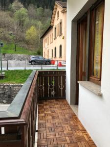 a balcony with a bench and a car on a street at Mountain House in Rigolato +9 photos