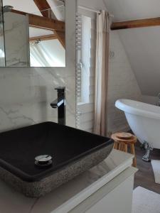 a bathroom with a bath tub and a sink at Vakantieverblijf Hof Ter Lucht in Petegem