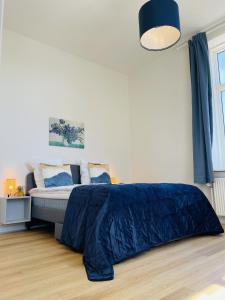 - une chambre avec un lit et une couette bleue dans l'établissement aday - Blue light suite apartment in the center of Hjorring, à Hjørring