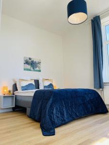 En eller flere senge i et værelse på aday - Blue light suite apartment in the center of Hjorring