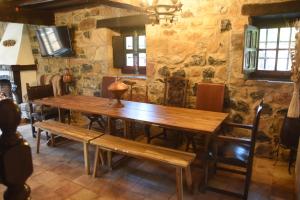 comedor con mesa de madera y bancos en Espectacular Casa Rural en Castaneda, en Socobio
