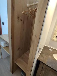 een badkamer met een houten deur en een wastafel bij Vakantieverblijf Hof Ter Lucht in Petegem