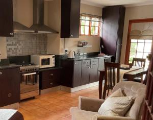 a kitchen with black cabinets and a stove top oven at Brighton Lodge - #Solar Energy #No Loadshedding in Port Elizabeth