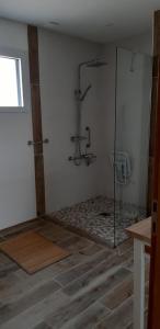 ein Bad mit einer Dusche und einer Glasduschkabine in der Unterkunft Gîte du blé normand in Corny