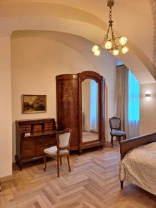a bedroom with a dresser and a mirror and a bed at Stadtpalais Marché-Suite maximal 2 Personen und 1 Kleinkind in Bautzen