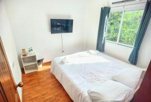 - une chambre avec un grand lit et une fenêtre dans l'établissement YYK Holiday Rooms, à Ban Khlong Krang