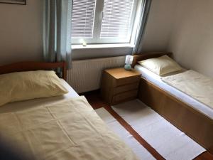a small bedroom with two beds and a window at Hava apartment in Sarajevo
