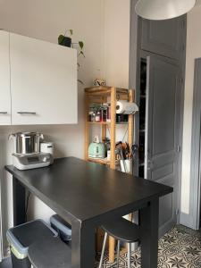 een zwarte tafel in een keuken met twee krukken bij Appartement Haussmannien in Épernay