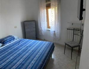 1 dormitorio con 1 cama, 1 silla y 1 ventana en Casa di Filippo, en Arcola