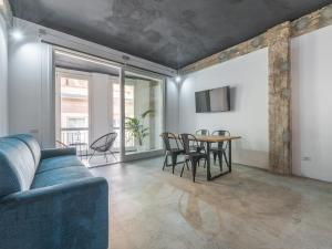 un salon avec un canapé bleu et une table dans l'établissement Ex Magazzini, à Cagliari