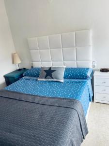 1 dormitorio con 1 cama grande y edredón azul en Acogedor apartamento en la Playa. Urbanización La Felicidad. Las Marinas en Dénia