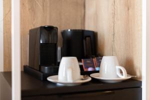a table with two cups and a coffee maker at Hafenhotel zu Putbus in Putbus +67 photos