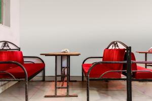 dwa czerwone krzesła i stół w pokoju w obiekcie OYO Flagship 69410 Sip & Bite Restaurant N Lodging w mieście Mansar