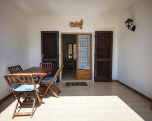 a dining room with a wooden table and chairs at Alloggi del Mirto a Morcone - Goelba in Capoliveri
