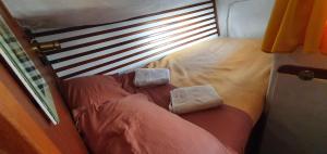 a bed with two pillows on top of it at Baladin - Dormir sur un voilier By Nuits au Port in La Rochelle