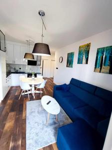 a living room with a blue couch and a table at Apartamenty Mazurska Bryza nad Iławką in Iława