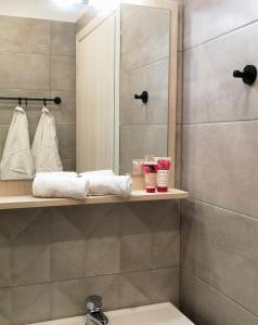 uma casa de banho com um chuveiro e um lavatório com toalhas em Iris Studios Chios em Karfas