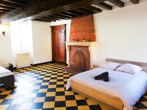 a bedroom with a bed and a fireplace at L'ancien relai de poste de Magny-Cours in Magny-Cours
