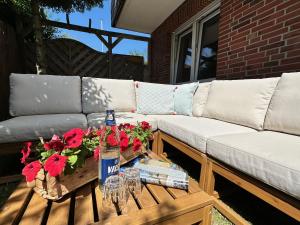 诺德奈AchterHuus的一张沙发和一张桌子,上面放着一瓶和鲜花