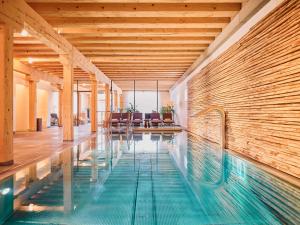 a swimming pool in a building with a wooden ceiling at G'Schloessl Murtal in Großlobming