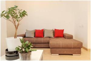 salon z brązową kanapą z czerwonymi poduszkami w obiekcie Casa San Carlo nel cuore di Torino w Turynie