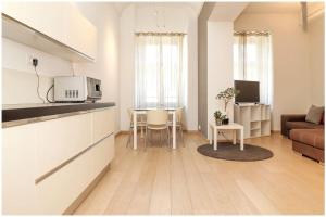 uma cozinha e sala de estar com uma mesa e um sofá em Casa San Carlo nel cuore di Torino em Turim